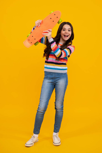 Fashion teenage lifestyle, beautiful teen girl with skateboard isolated on studio background. Happy teenager, positive and smiling emotions of teen girl - Φωτογραφία, εικόνα