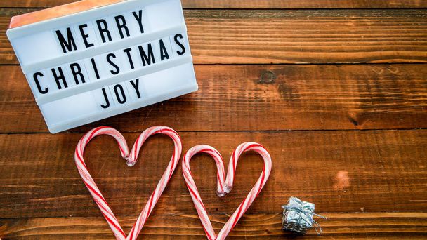 Веселые рождественские пожелания с сердечками на деревянном столе с копировальным пространством - Фото, изображение