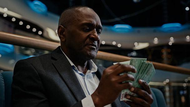 Umsichtiges Denken durchdachte afroamerikanische Geschäftsmann Arbeiter Unternehmer Mann reicher Arbeitgeber Zählen Geld Bargeld Dollar Budgeteinsparungen drinnen in Einkaufszentrum denken über finanzielle Gehaltsfinanzierung - Foto, Bild