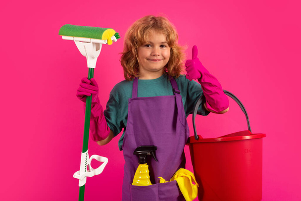 Portrait of child cleaning, concept growth, development, family relationships. Housekeeping and home cleaning concept. Child use duster and gloves for cleaning. Studio isolated background - Фото, изображение