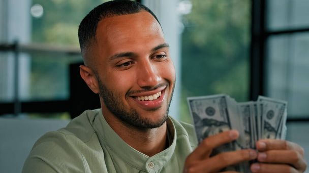 mężczyzna portret szczęśliwy uśmiechnięty bogaty sukces Latynos licząc pieniądze Afroamerykanin biznesmen gospodarstwa fan dolarów banknoty pieniężne wygrana nagrody pieniężne cieszyć wymiany oszczędności pensja finanse łapówka - Zdjęcie, obraz