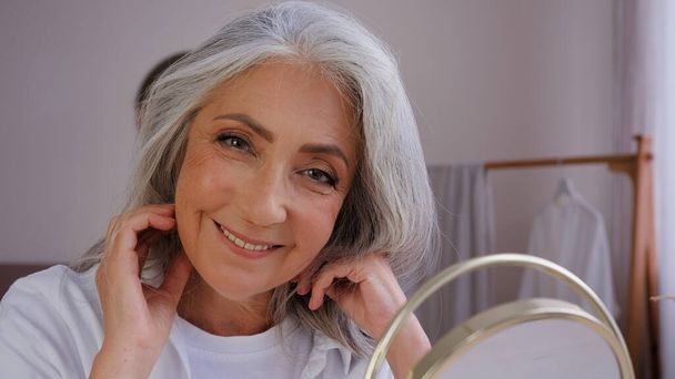 閉じるアップ古いですシニア熟女おばあちゃんモデル女性見てミラー反射幸せとともにナチュラルケラチンシャンプー回復結果60歳白人女性の回復に触れる長い髪のケア - 写真・画像
