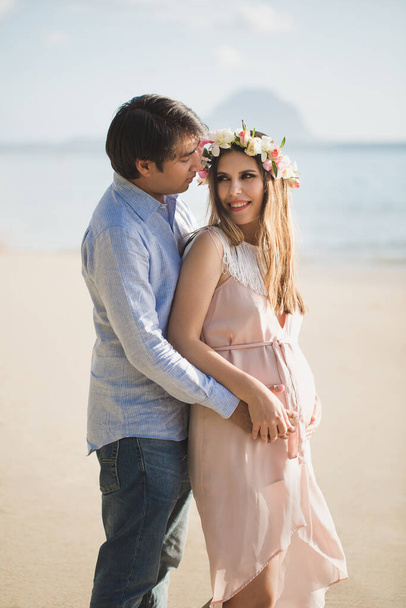 Beautiful pregnant girl and man on the beach - Фото, зображення