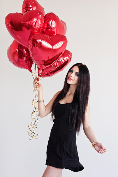 Beautiful brunette young woman with a heart-shaped balloons. Valentine's day. - Foto, Bild