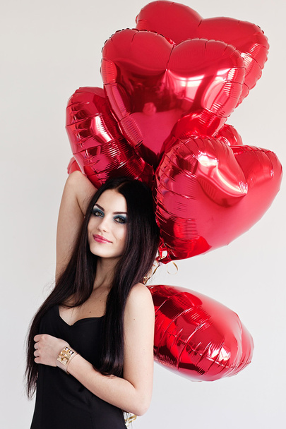 Beautiful brunette young woman with a heart-shaped balloons. Valentine's day. - Foto, imagen