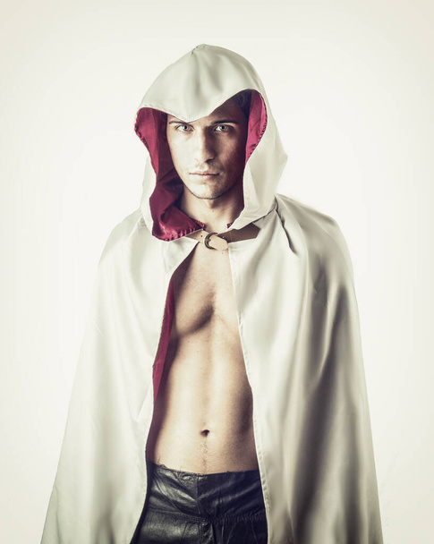 Handsome young man in old fashioned cloak on light background - Photo, Image