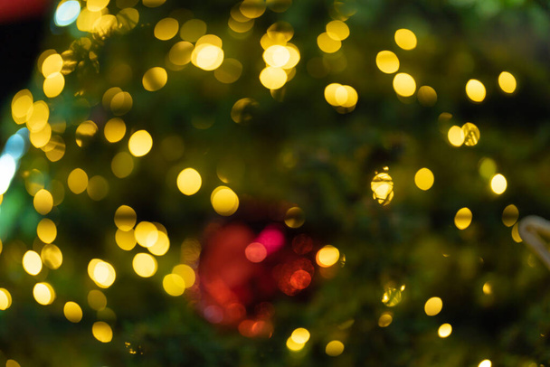 Borroso bokeh de un árbol de Navidad aislado sobre fondo negro por la noche en los viajes en concepto de vacaciones de vacaciones. Navidad. - Foto, imagen