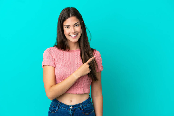 Young Brazilian woman isolated on blue background pointing to the side to present a product - Foto, immagini