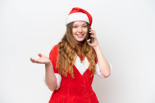 Fiatal fehér nő karácsonyi ruha elszigetelt fehér háttér tartja a beszélgetést a mobiltelefon valakivel - Fotó, kép