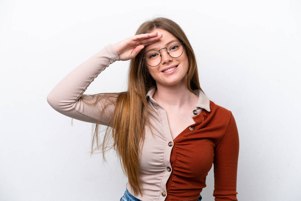 Young caucasian woman isolated on white background saluting with hand with happy expression - Foto, Imagen