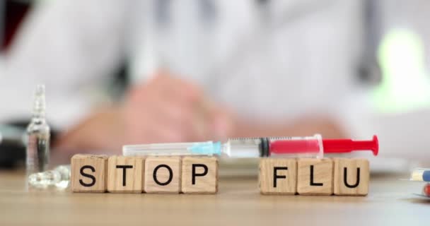 Mot arrêter la grippe sur cubes en bois sur fond de médecin gros plan film 4k ralenti. Concept de vaccination antigrippale - Séquence, vidéo