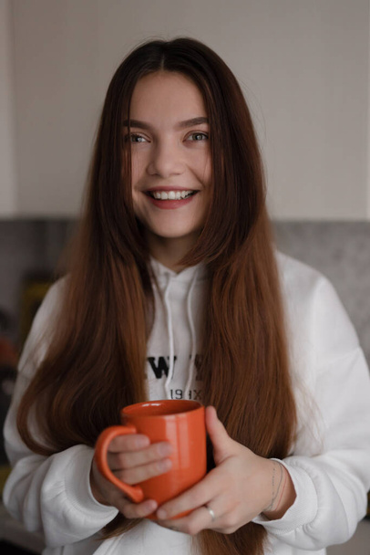 Smiling woman vertical portrait holding cup at home - 写真・画像