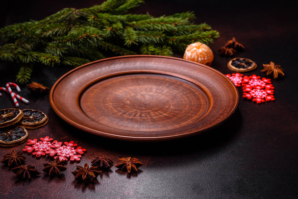 Christmas table with empty plate and surface with New Year's decorations. Preparation of a holiday dinner - Photo, Image