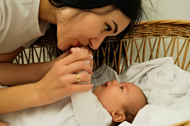 Η μητέρα φιλάει το χέρι ενός νεογέννητου. η έννοια του φιλιού, μητρική αγάπη. - Φωτογραφία, εικόνα