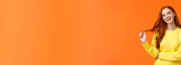 Insouciant beau, souriant toothy rousse femme, fille aux cheveux roux rire comme des amis bavards, rouler la boucle sur les cheveux, incliner la tête et sourire joyeusement, avoir la conversation, fond orange
. - Photo, image