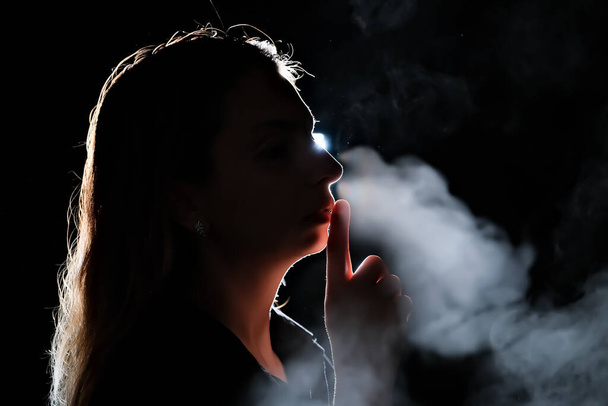 silhouette of a girl in the dark. smoke . steam . girl in a dark room. - Fotó, kép