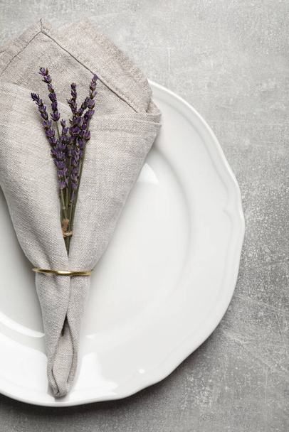 Plate with fabric napkin, decorative ring and lavender on gray background, top view - Foto, Imagem