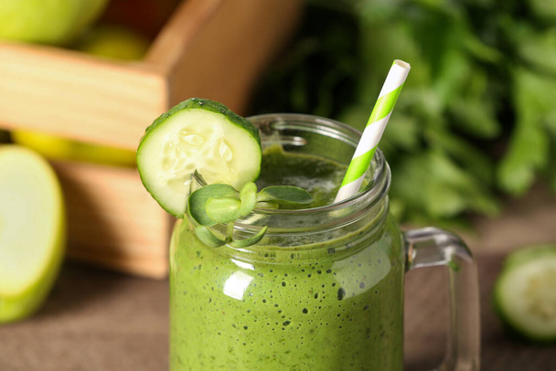 Fresh green smoothie and ingredients on wooden table, closeup - Фото, зображення