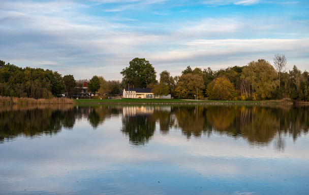 Rotselaar, Região Brabante Flamenga, Bélgica - 11 11 2022 - Vista panorâmica da lagoa d 'água De Plas com árvores refletoras nas cores do outono - Foto, Imagem