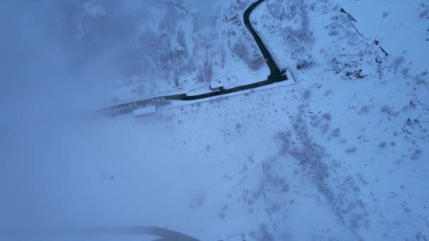 Montañas nevadas con árboles de coníferas en las nubes. Presa Medeo. Todo está en niebla y nieve. Navidad y Año Nuevo han llegado. Vista aérea desde el dron en carretera, presa y árboles. Almaty, Kazajstán - Imágenes, Vídeo