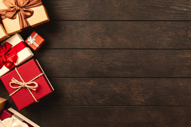 czerwone i złote prezenty pudełka na drewnianym stole z miejsca na tekst - Zdjęcie, obraz