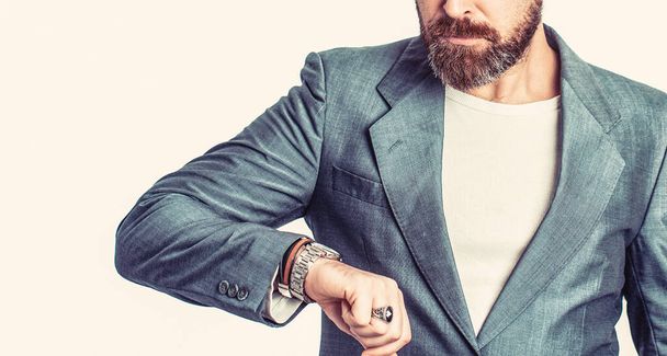 Egy üzletember időt mutat a karóráján. Kéz a kézben óra egy üzleti öltöny. Elegáns, jóképű öltönyös férfi. Üzletember ellenőrzi az órát. - Fotó, kép