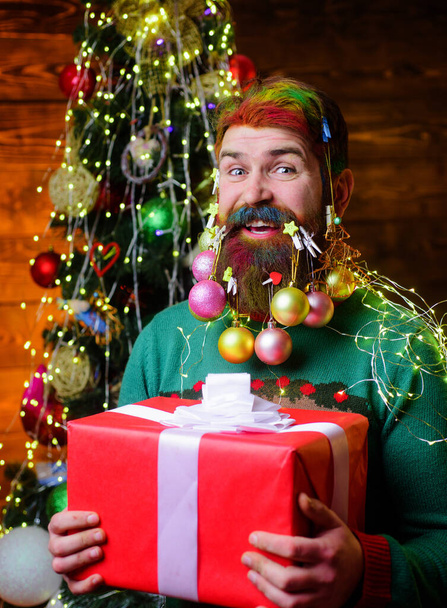 メリークリスマスと幸せな新年。髭を生やした笑顔の男がプレゼント箱を持っている。冬休み - 写真・画像