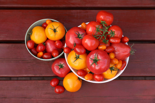Bowls with fresh tomatoes on wooden table, flat lay - Foto, Imagen