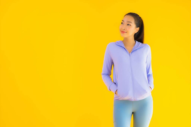 Retrato bonito jovem asiático esporte mulher com sportwear pronto para o exercício no amarelo isolado fundo
 - Foto, Imagem