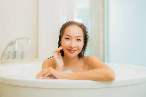 Портрет красивая молодая азиатская женщина расслабиться улыбка в ванной комнате интерьера - Фото, изображение