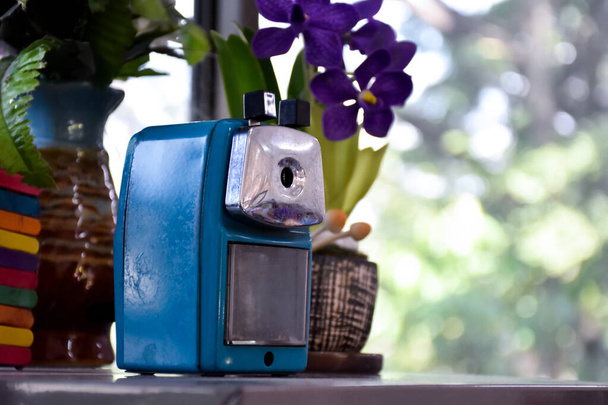 Old metal pencil sharpener on metal cabinet, blurr background, soft and selective focus. - Photo, Image