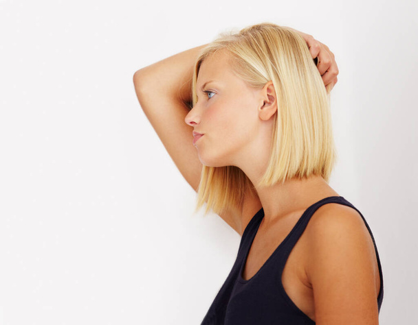 Feeling fed-up. Profile of a young woman standing with her hand in her hair - Foto, imagen