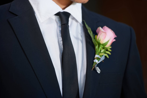 Limpio y ordenado para su gran día. Imagen recortada de un novio con una rosa rosada en su chaqueta - Foto, imagen