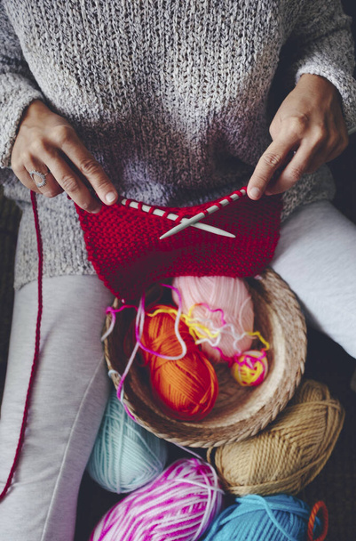 Above view of woman doing knit work leisure activity at home indoor. Knitting with colorful wool. Making garment home made art style. People and hobby concept lifestyle. Hand made work inside house - Foto, Imagem