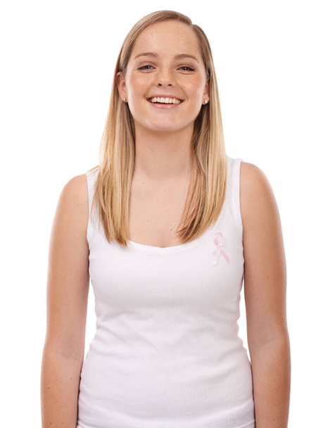 Ένας σκοπός που αξίζει να υποστηριχθεί. Μια νεαρή γυναίκα με μια κορδέλα καρκίνου του μαστού απομονωμένη σε λευκό - Φωτογραφία, εικόνα