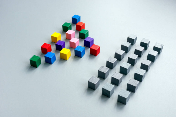 Lines of gray cubes and pyramid of multi-colored ones as a concept of diversity. - Foto, afbeelding