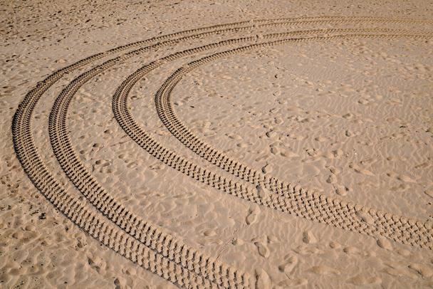 αυτοκίνητο αποτύπωμα ελαστικού και τροχού κομμάτι στην άμμο στην παραλία της ερήμου σε λεπτή άμμο της ερήμου αμμόλοφο - Φωτογραφία, εικόνα
