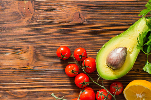 Guacamole on wooden table surrounded by its ingridients - 写真・画像