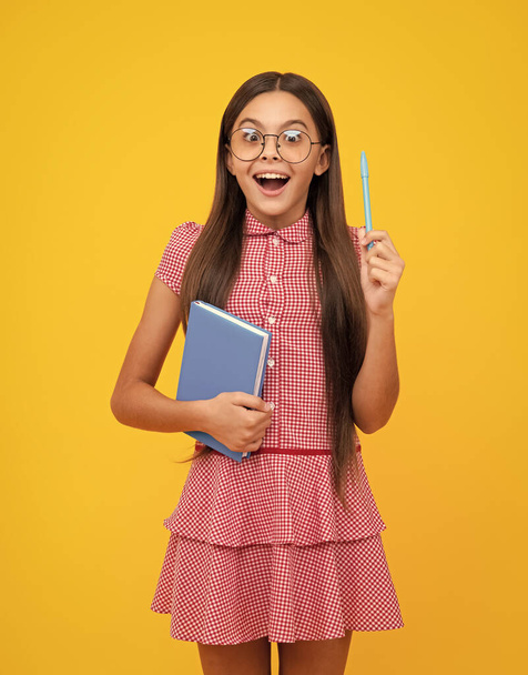 Amazed teen girl. Teenage school girl with books. Schoolgirl student. Excited expression, cheerful and glad - Foto, afbeelding