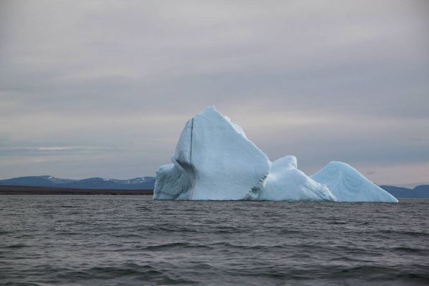 カナダ、ヌナヴートの池の入口付近で、北極の風景の中で夜近くに氷山と氷を絞り出しました。 - 写真・画像