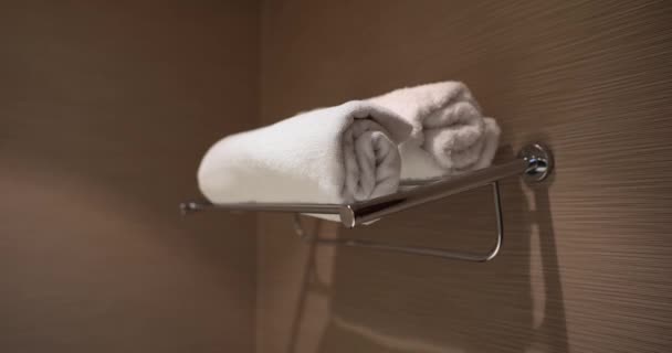 Zwei weiße Handtücher im Regal in der Hoteldusche. Schlaf- oder Hoteldienstleistungen und Körperhygiene - Filmmaterial, Video