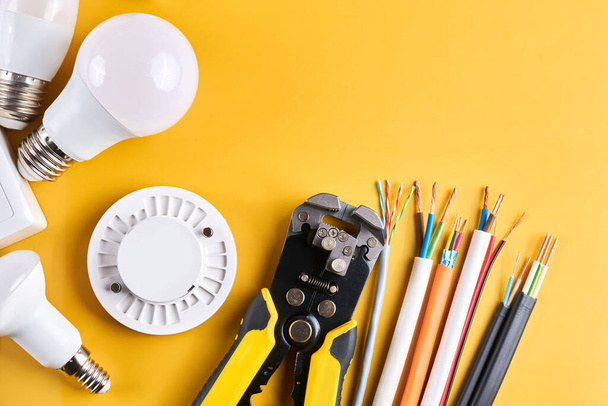 Electrical tools set with dimmer switch isolated on yellow background with copy space, controllable lighting. Saving energy concept, building and renovation - Foto, Imagen