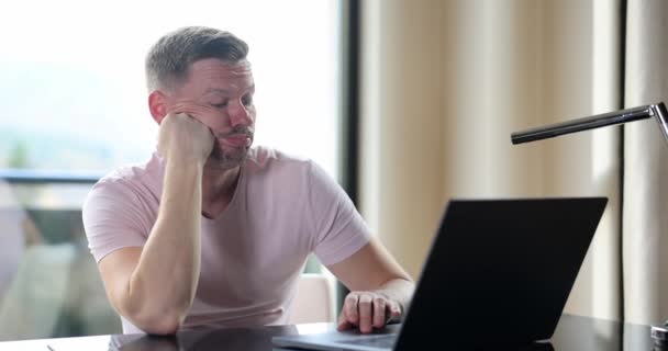 Πορτρέτο του λυπημένου δυσαρεστημένου άνδρα σε freelancer, ενώ εργάζονται σε φορητό υπολογιστή. Οικονομικά προβλήματα στην εργασία - Πλάνα, βίντεο