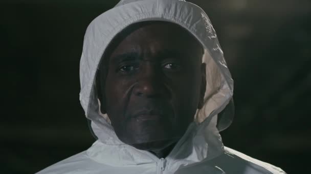 Portret mannelijke arts medisch medewerker in speciale beschermende witte chemische uniform vecht met epidemie op zoek naar camera met droevige uitdrukking gefrustreerd Afrikaanse Amerikaanse man voelt zich overstuur omdat pandemie - Video