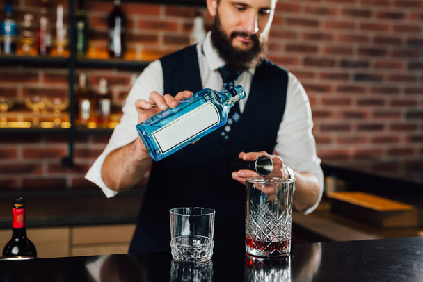 Bartender pours alcoholic drink into a cocktail mix - Foto, imagen