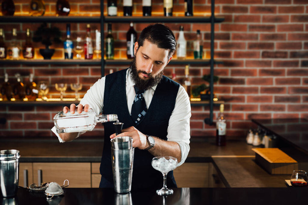 Barman pours vodka in a dispenser - Foto, immagini