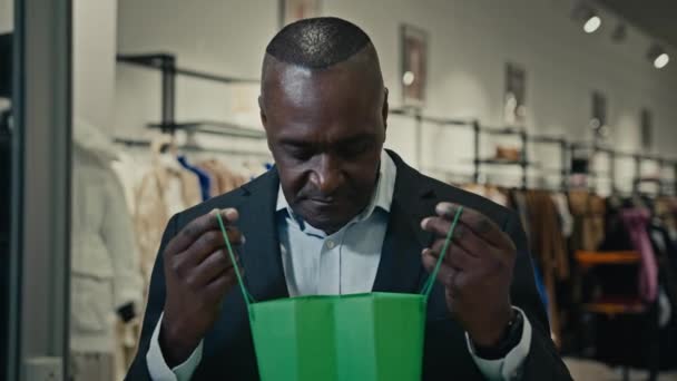 Africký dospělý podnikatel středního věku muž kupec spotřebitel muž v obchodě obchoďák při pohledu uvnitř nákupní tašky nákup rozrušený smutné selhání se současným nákupem nespokojen se slevou špatné reakce - Záběry, video
