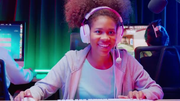 Νεαρή Αφρο-Αμερικανίδα γυναίκα και ομάδα που φορούν ακουστικά παίζουν βιντεοπαιχνίδι και ζουν σε απευθείας σύνδεση με μικρόφωνο, gaming και esport για ανταγωνισμό ή χύτευση παιχνίδι, μετάδοση και ψυχαγωγία έννοια. - Πλάνα, βίντεο