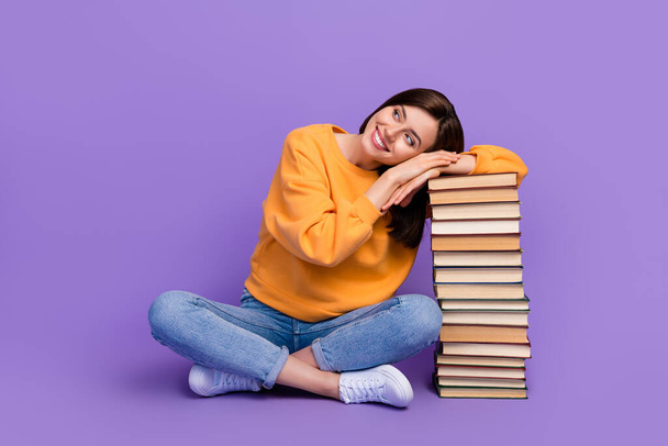 Full body size photo of young attractive funky woman dreamy sitting relaxed stack books looking empty space advert new offer isolated on purple color background. - Foto, Bild