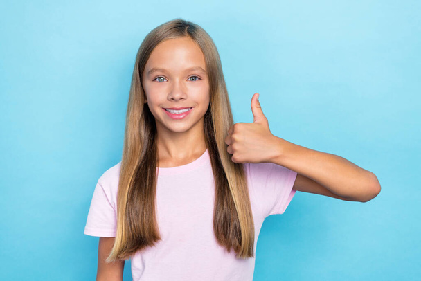 Portrait of cheerful optimistic school girl with straight hairstyle wear pink t-shirt showing thumb up isolated on blue color background. - Foto, Bild